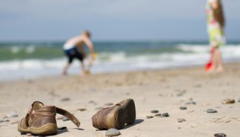 Kids playing on beach with childrens' shoes laying on sand | Experienced Idaho Podiatrist