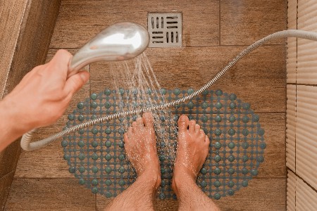 Man-washing-feet-in-shower