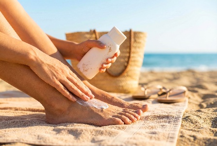 Person-applying-foot-sun-protection