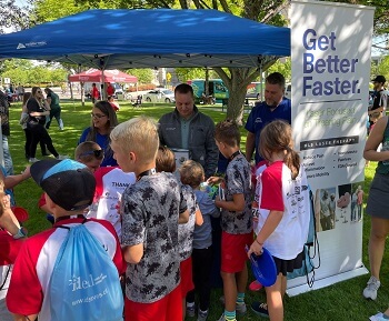 Kids gathered at Rocky Foot & Ankle booth during Capitol Classic Kids Race 2024