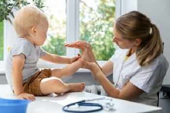 Podiatrist examining child&rsquo;s foot for custom orthotics