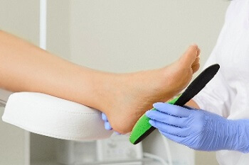 Podiatrist fitting a custom foot orthotic