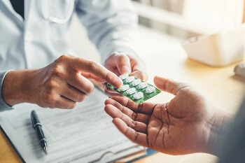 Doctor providing EBM medical food tablets for chronic foot pain relief