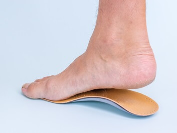 man with flat foot fitting for orthotic | Experienced Idaho Podiatrist