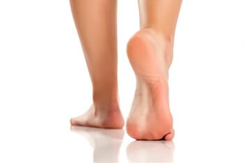 person walking away on bare feet | Experienced Idaho Podiatrist