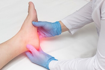 Doctor examining patient&rsquo;s heel to diagnose plantar fasciitis