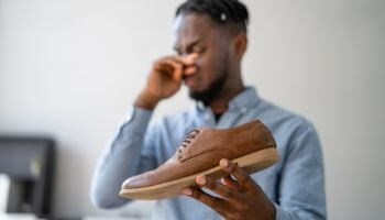 Man smelling smelly shoe from foot odor