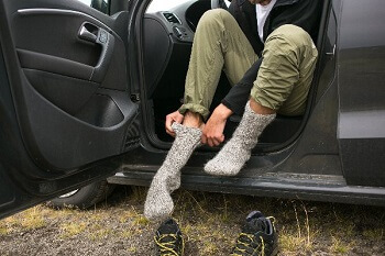 Person putting on warm socks in winter to protect feet