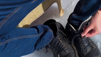 Person removing winter boots to keep feet dry and healthy